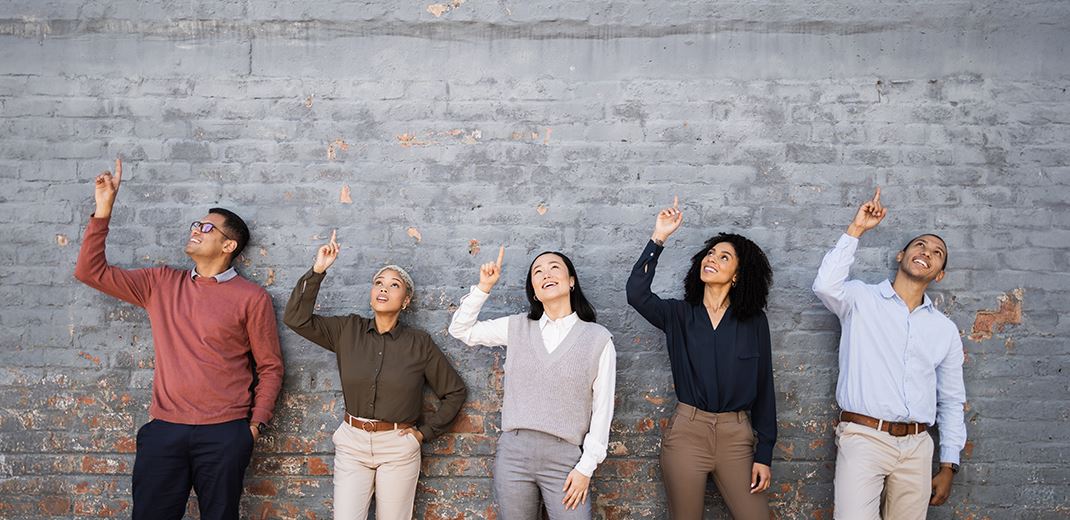 people standing in front of a wall pointing up