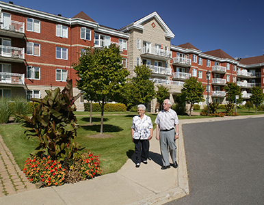 Two elderly individuals walking outside of a residential community