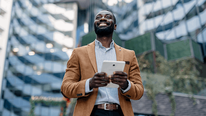 Man smiling while looking up and holding tablet