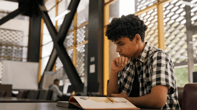 Student intensely reading book in common area
