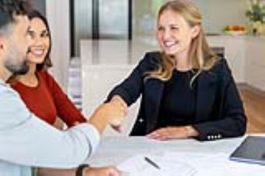 Woman shaking hands with couple after signing lease