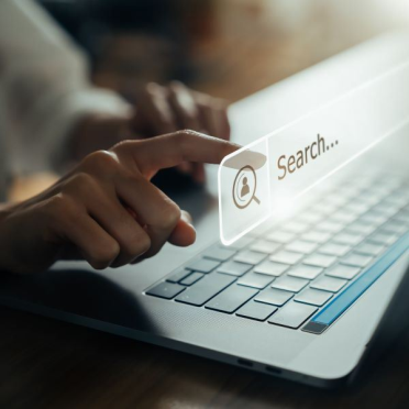 Person clicking a search bar hovering above their laptop