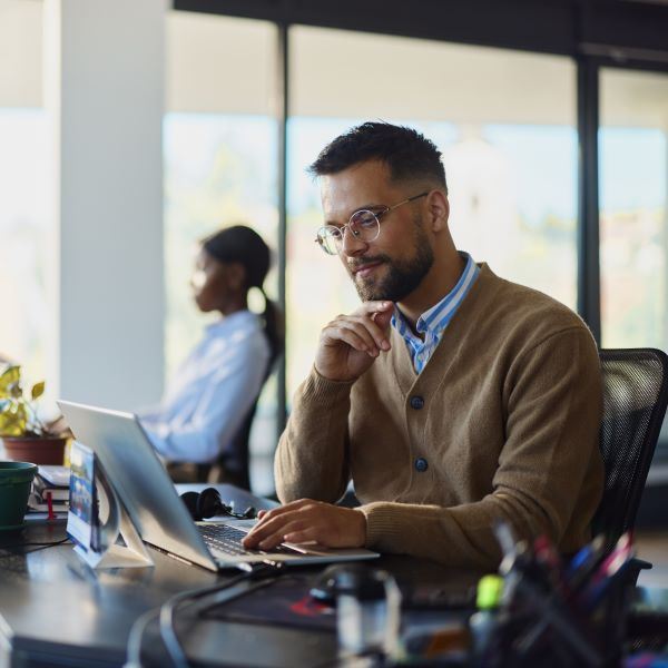 Man smiling while working on computer